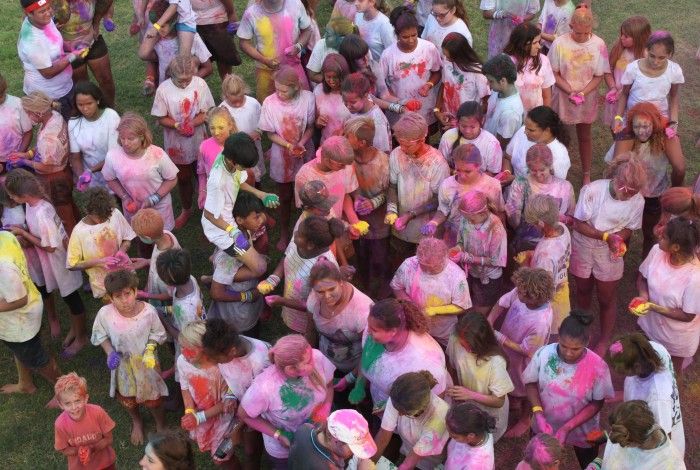 Group of youths covered in purple chalk powder celebrating Youth Week together